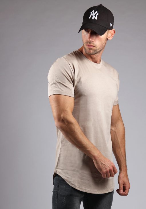Rechter vooraanzicht heren T-shirt in desert kleur en een slimfit pasvorm. Het model draagt een donkere jeans en heeft zijn armen langs zijn lichaam hangen.