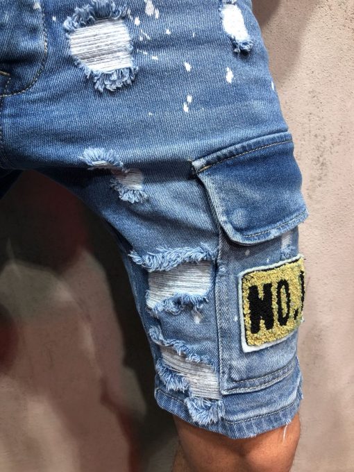 Close up van blauwe jean shorts met damaged details en patches.