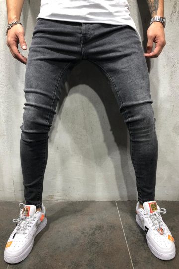 Voorzijde grijze denim heren jeans met skinny pasvorm, gemaakt van stretch stof. Gecombineerd met wit T-shirt en witte sneakers.