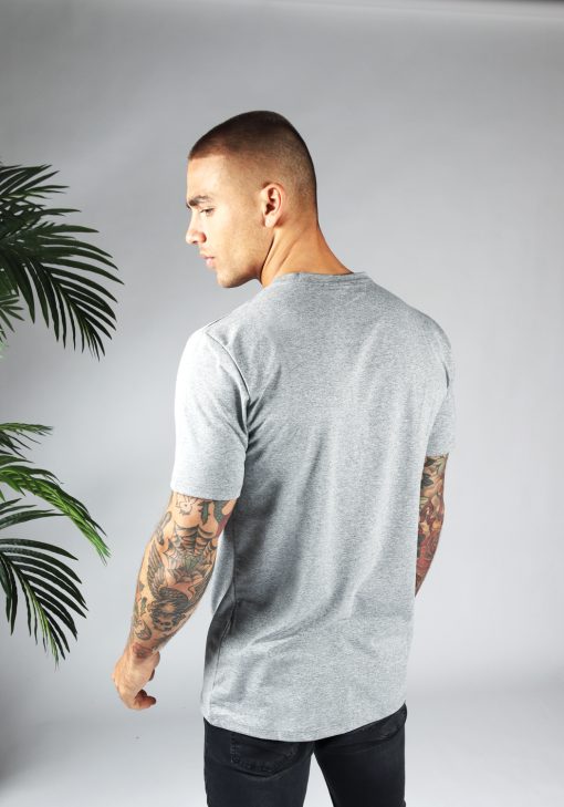 Achteraanzicht heren T-shirt in grijze kleur en een straight fit pasvorm. Het model draagt een donkere jeans en heeft zijn armen langs zijn lichaam.