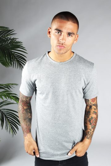 Vooraanzicht heren T-shirt in grijze kleur en een straight fit pasvorm. Het model draagt een donkere jeans en heeft zijn linkerhand in zijn linker broekzak.