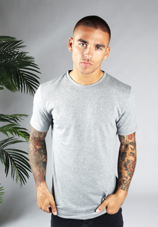 Vooraanzicht heren T-shirt in grijze kleur en een straight fit pasvorm. Het model draagt een donkere jeans en heeft zijn linkerhand in zijn linker broekzak.