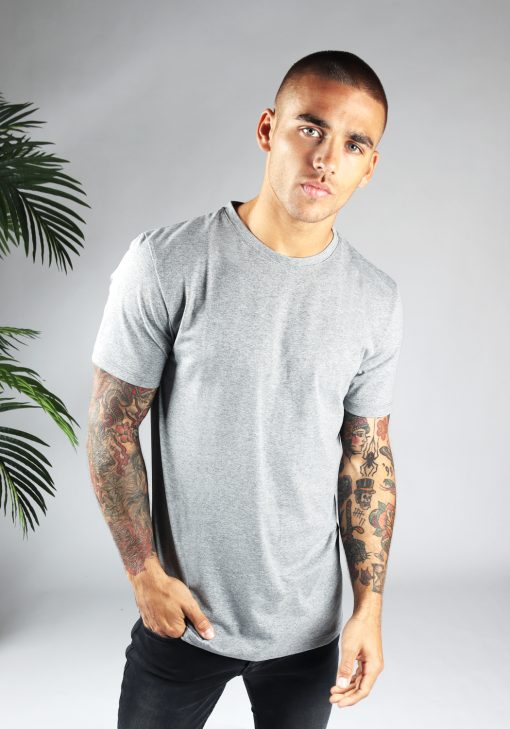 Vooraanzicht heren T-shirt in grijze kleur en een straight fit pasvorm. Het model draagt een donkere jeans en heeft zijn rechterhand in zijn rechter broekzak.