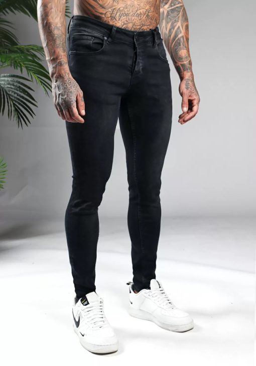 Rechter zijaanzicht zwarte heren skinny jeans van stretch stof. Voorzien van vier zakken, knoopsluiting en riemlussen.