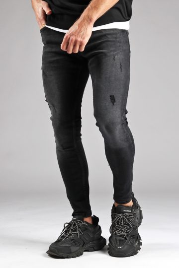 Voorkant zwarte denmin heren jeans skinny pasvorm, damaged uitstraling, broekzakken en knoopsluiting. Gecombineerd met zwarte sneakers en zwart T-shirt