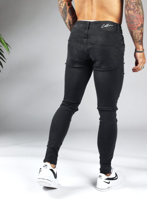 Achterkant zwarte denmin heren jeans skinny pasvorm, damaged uitstraling, broekzakken en knoopsluiting.