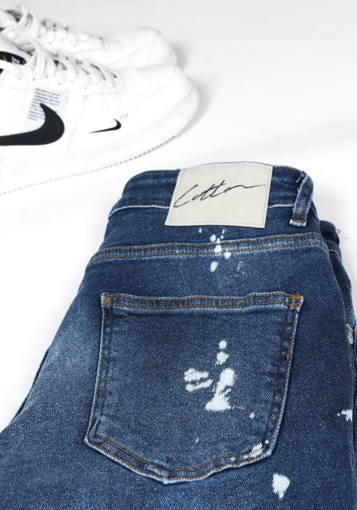 Close up Cotton-logo op achterkant denim heren jeans skinny fit met damaged look, broekzakken, knoopsluiting en riemlussen.