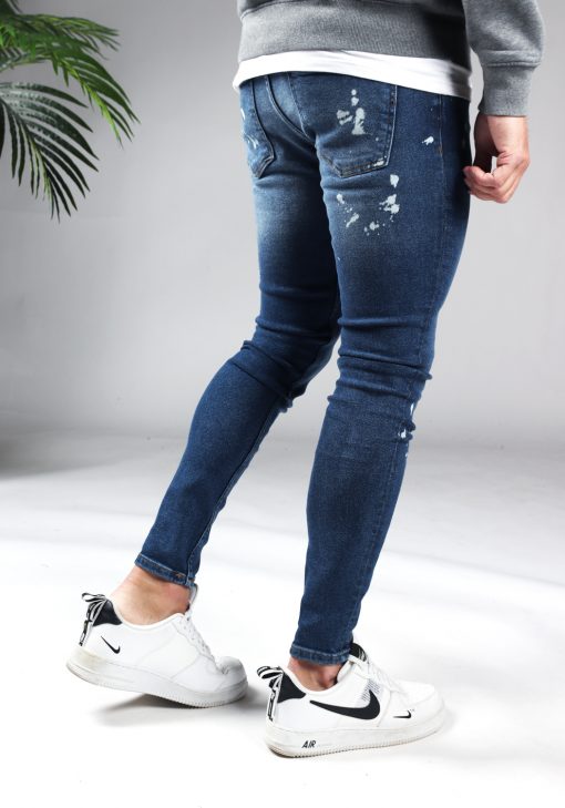 Achterkant denim heren jeans skinny fit met damaged look, broekzakken, knoopsluiting en riemlussen.