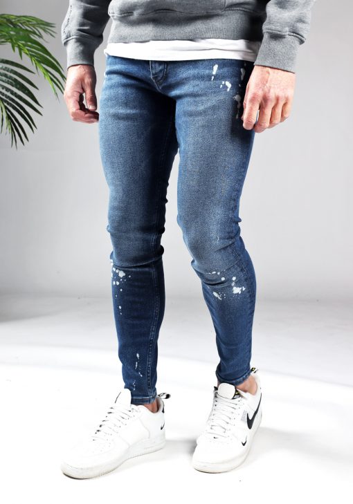 Linker zijaanzicht denim heren jeans skinny fit met damaged look, broekzakken, knoopsluiting en riemlussen.