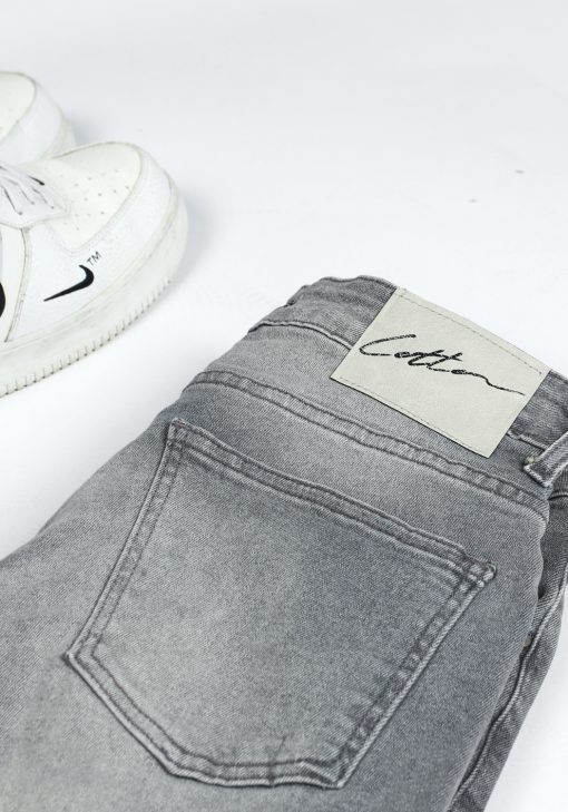 Close up Cotton-logo op achterkant van lichtgrijze heren skinny jeans.