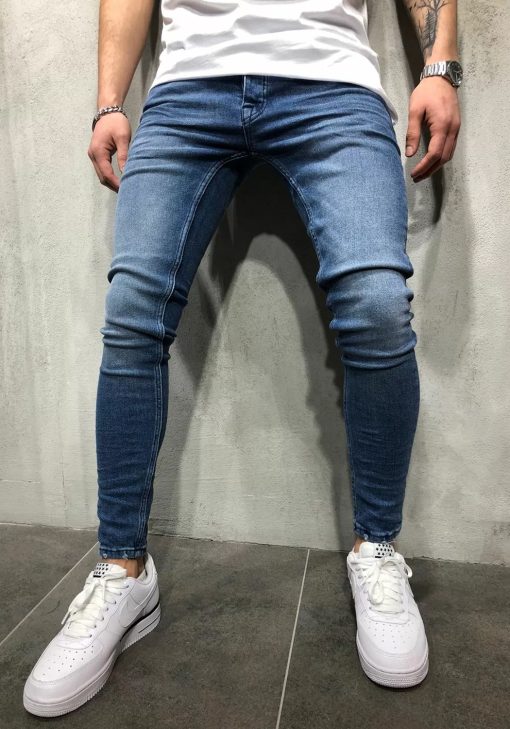 Voorkant blauwe heren skinny jeans met twee broekzakken, twee kontzakken, knoopsluiting en riemlussen. Gecombineerd met witte sneakers en wit T-shirt.