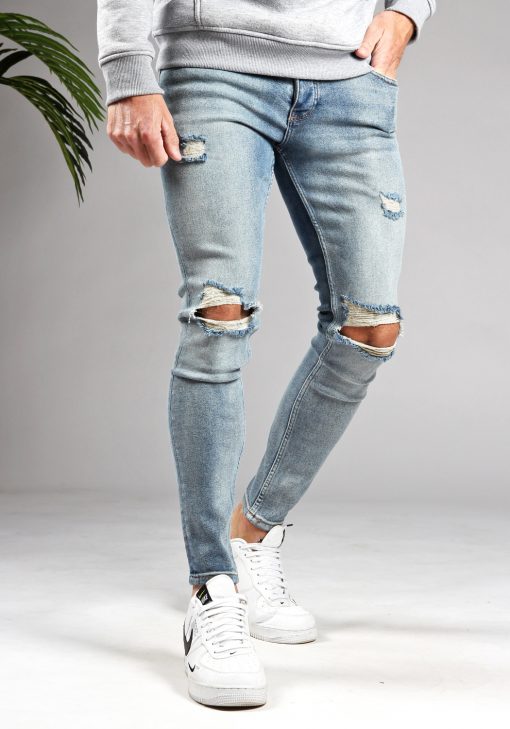 Vooraanzicht lichtblauwe heren skinny jeans met damaged look, scheuren bij de knieën, twee zakken aan de voorzijde, twee achterzakken, knoopsluiting en riemlussen.