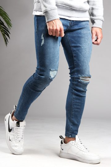 Rechter zijaanzicht blauwe denim heren skinny jeans, met damaged afwerking en gemaakt van stretch stof. Voorzien van vier zakken, knoopsluiting en riemlussen.