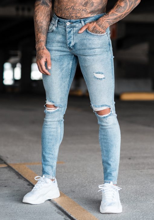 Voorzijde denim heren skinny jeans met scheuren. Gemaakt van stretch stof en voorzien van vier zakken, knoopsluiting en riemlussen.