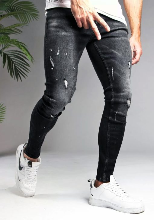 Rechter zijaanzicht zwarte heren skinny jeans met verfspetters en kleine scheuren, gemaakt van stretch stof. Voorzien van vier zakken, knoopsluiting en riemlussen.