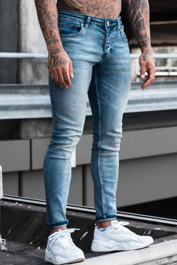 Voorkant licht blauwe light wash heren skinny jeans, gemaakt van stretch stof. Voorzien van vier zakken, knoopsluiting en riemlussen.