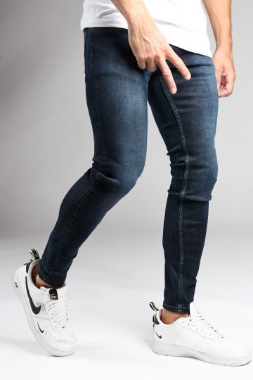 Rechter zijkant donkerblauwe heren skinny jeans van stretch stof. Voorzien van vier zakken, knoopsluiting en riemlussen.