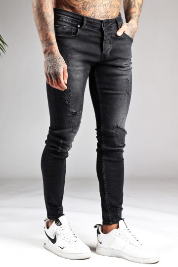 Voorkant zwarte heren jeans met skinny pasvorm en lichte damaged uitstraling, voorzien van vier zakken, knoopsluiting en riemlussen.