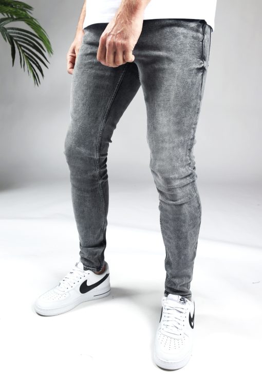 Linker zijkant grijze heren skinny jeans met broekzakken, knoopsluiting en riemlussen. Gecombineerd met wit T-shirt en witte sneakers.