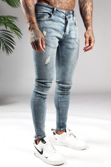 Rechter zijaanzicht lichtblauwe damaged heren skinny jeans met broekzakken, knoopsluiting en riemlussen.