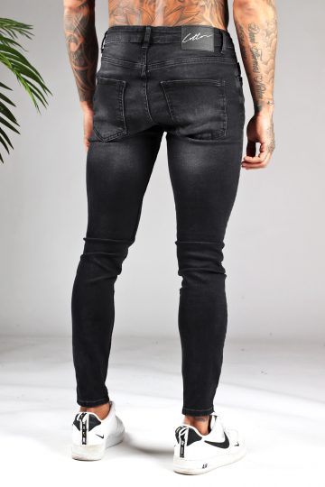 Achterkant zwarte heren jeans met skinny pasvorm en lichte damaged uitstraling, voorzien van vier zakken, knoopsluiting en riemlussen.
