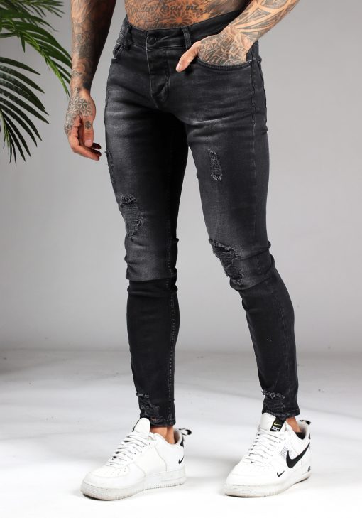 Linker zijaanzicht zwarte heren jeans met skinny pasvorm en lichte damaged uitstraling, voorzien van vier zakken, knoopsluiting en riemlussen.