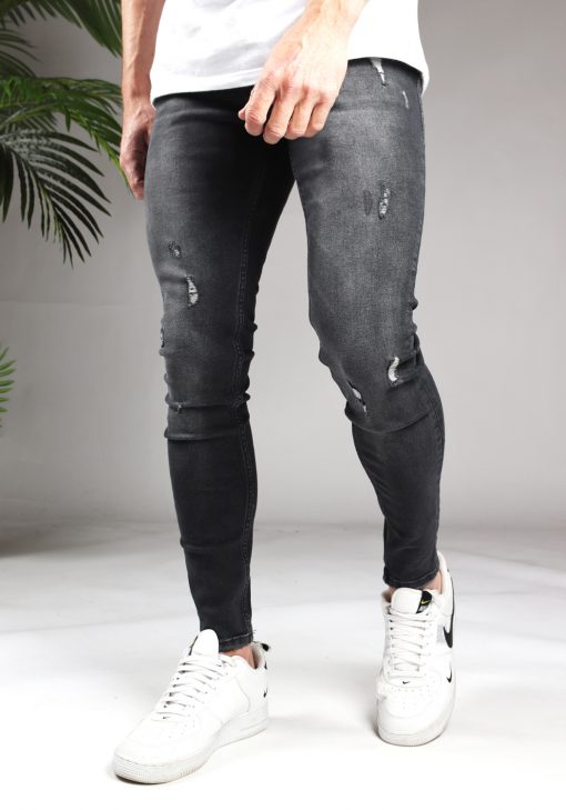 Voorkant donker grijze denim heren jeans met skinny pasvorm en damaged look. Gemaakt van stretch stof en voorzien van broekzakken, knoopsluiting en riemlussen.