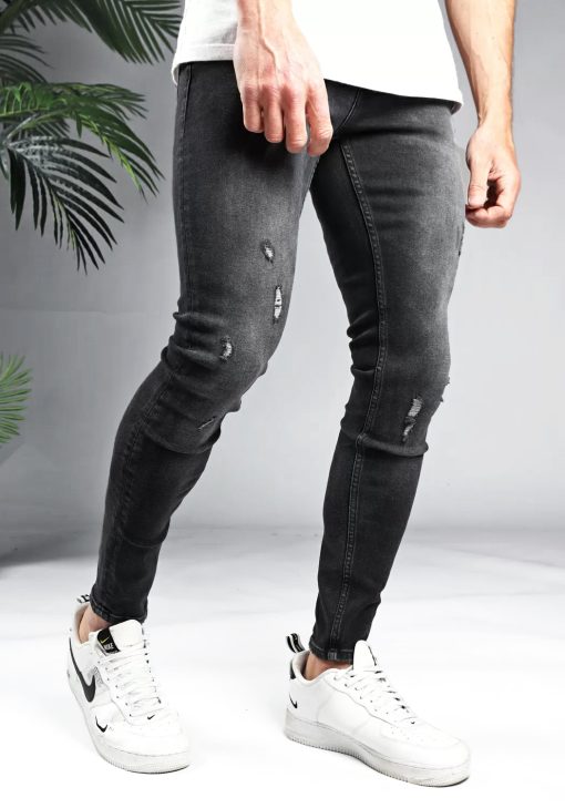 Voorkant donker grijze denim heren jeans met skinny pasvorm en damaged look. Gemaakt van stretch stof en voorzien van broekzakken, knoopsluiting en riemlussen.