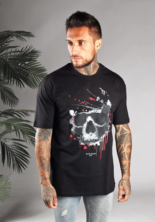 Vooraanzicht van heren T-shirt in zwarte kleur, met ronde hals en doodskop print op de borst. Het model kijkt opzij en heeft zijn armen langs zijn lichaam.