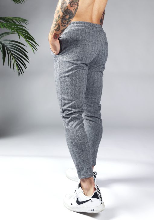 Achterkant comfortabele heren chino broek in grijze kleur, met skinny fit en gemaakt van luxe stretch stof. Voorzien van twee broekzakken en rekbare taille met zwart trekkoord. Gecombineerd met witte sneakers.