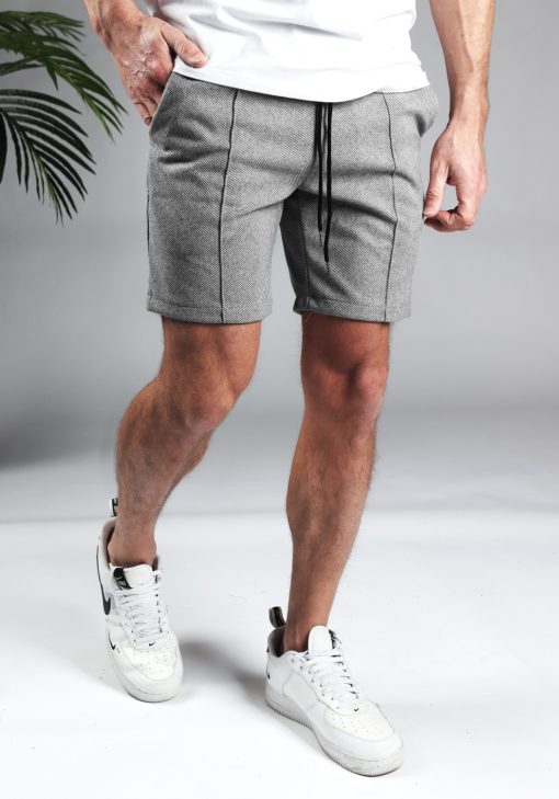 Rechter zijaanzicht comfortabele heren chino shorts in grijze kleur, met skinny fit en gemaakt van luxe stretch stof. Voorzien van twee broekzakken en rekbare taille met trekkoord. Gecombineerd met witte sneakers en een wit T-shirt.