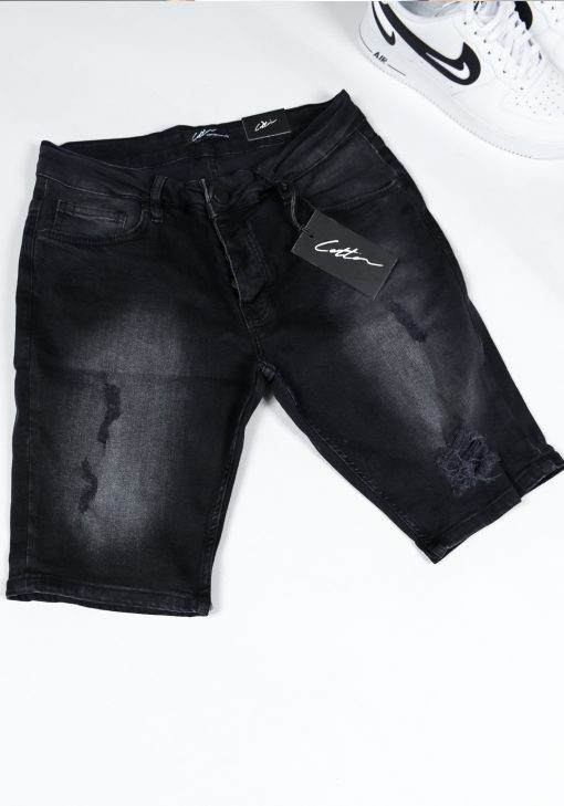 Shot bovenaanzicht van zwarte jean shorts met damaged details en een zwart label met het witte signature cotton logo.