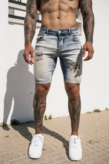 Vooraanzicht van model gekleed in lichtblauwe trench jean shorts. De shorts hebben damaged details en een skinny fit.