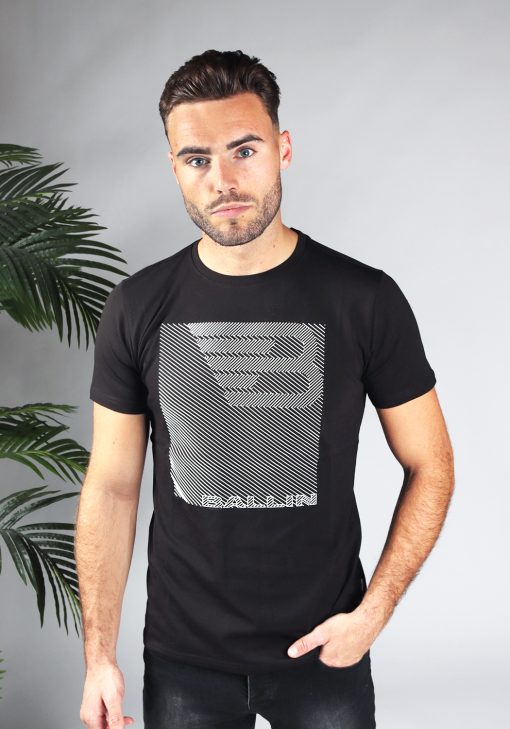 Vooraanzicht van model gekleed in zwart t-shirt met een wit zigzag print en het Ballin logo op de voorkant.