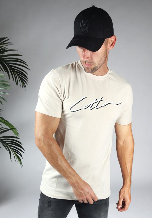 Vooraanzicht heren T-shirt in beige kleur, met ronde hals en gemaakt van katoen lycra mix stof. Het T-shirt is voorzien van een straight fit pasvorm en het Cotton-logo op de borst in het zwart en wit. Het model draagt een pet.