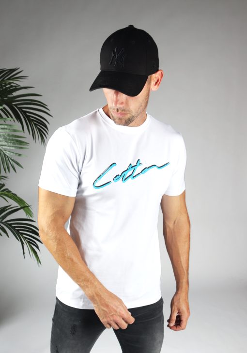 Vooraanzicht heren T-shirt in witte kleur, met ronde hals en gemaakt van katoen lycra mix stof. Het T-shirt is voorzien van een straight fit pasvorm en het Cotton-logo op de borst in het blauw en zwart. Het model draagt een pet en kijkt naar rechts.