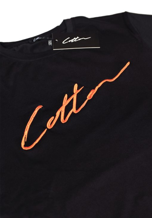 Close-up heren T-shirt in zwarte kleur, met ronde hals en gemaakt van katoen lycra mix stof. Het T-shirt is voorzien van een kledinglabel en het Cotton-logo op de borst in het oranje.