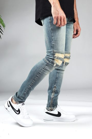 Rechter zijaanzicht lichtblauwe heren jeans slim fit model met scheuren bij de knieën en een rits aan de binnenkant van de enkel.