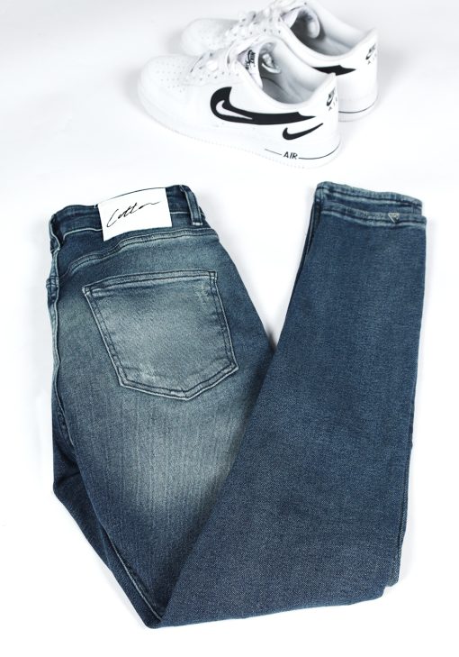 Achterkant opgevouwen blauwe heren skinny jeans met scheuren in de broekspijpen en gemaakt van stretch stof.