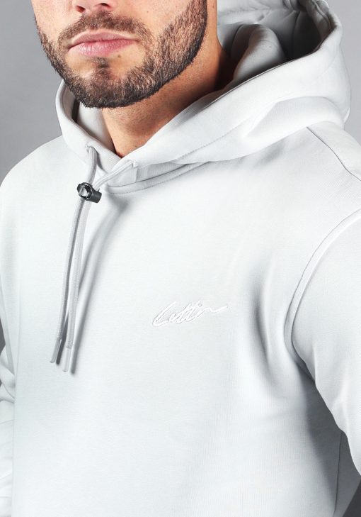 Closeup van lichtblauwe pop hoodie met het witte signature cotton logo op de borst.