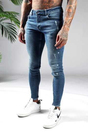 Linker zijaanzicht denim heren skinny jeans met damaged look en verfspetters. Gemaakt van stretch stof en voorzien van vier zakken, knoopsluiting en riemlussen.