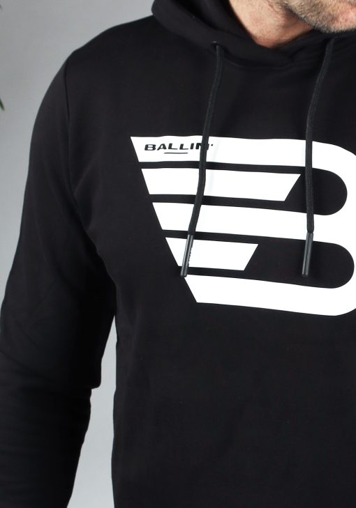 Close up van model gekleed in zwarte hoodie met het grote witte ballin logo in het midden van de borst.