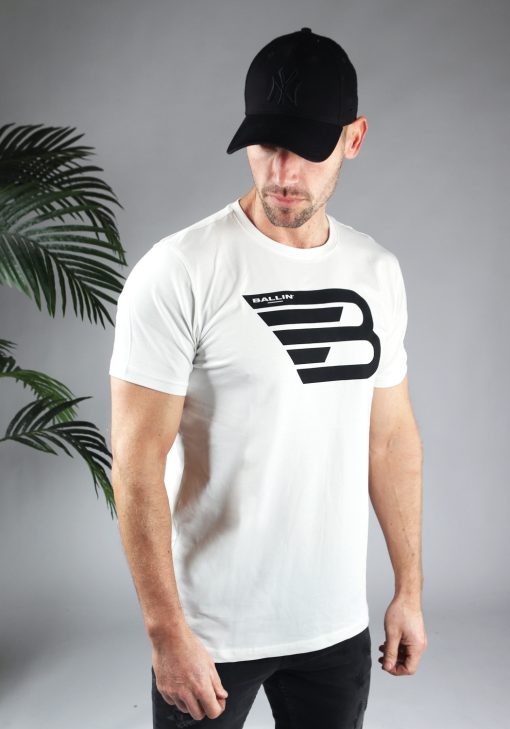 Schuin vooraanzicht van model gekleed in wit shirt met het grote zwarte Ballin logo op de voorkant.