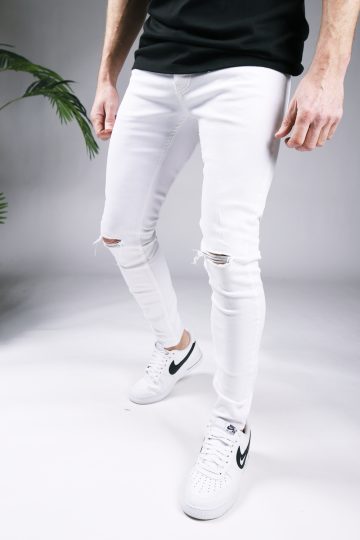 Linker zijaanzicht witte heren skinny jeans met scheuren, gemaakt van stretch stof. Voorzien van broekzakken, een knoopsluiting en riemlussen.