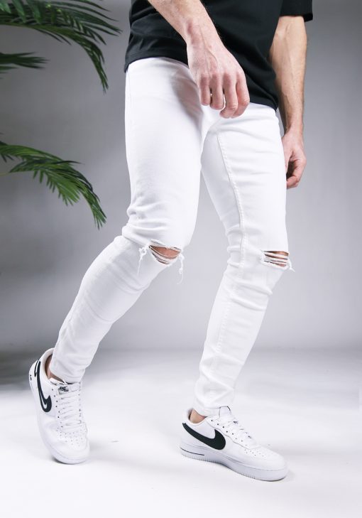 Rechter zijaanzicht witte heren skinny jeans met scheuren, gemaakt van stretch stof. Voorzien van broekzakken, een knoopsluiting en riemlussen.
