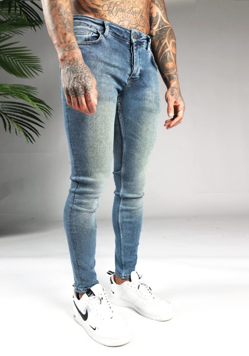 Rechter zijaanzicht blauwe denim heren jeans skinny pasvorm van stretch stof. Voorzien van zakken aan de voor- en achterzijde, knoopsluiting en riemlussen.