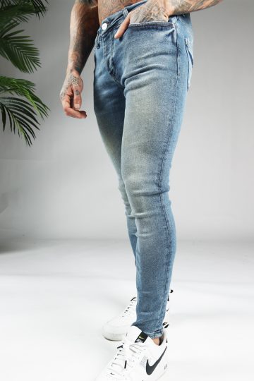 Linker zijaanzicht blauwe denim heren jeans skinny pasvorm van stretch stof. Voorzien van zakken aan de voor- en achterzijde, knoopsluiting en riemlussen.