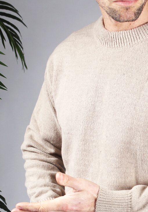 Close up van model gekleed in een lichtbruine knit sweater met een oversized fit.