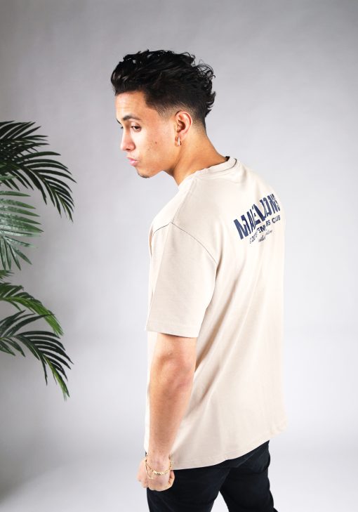 Schuin achteraanzicht van heren T-shirt in beige kleur, met een ronde hals en een relaxed fit pasvorm. Het T-shirt is voorzien van navy tekst op de achterkant.