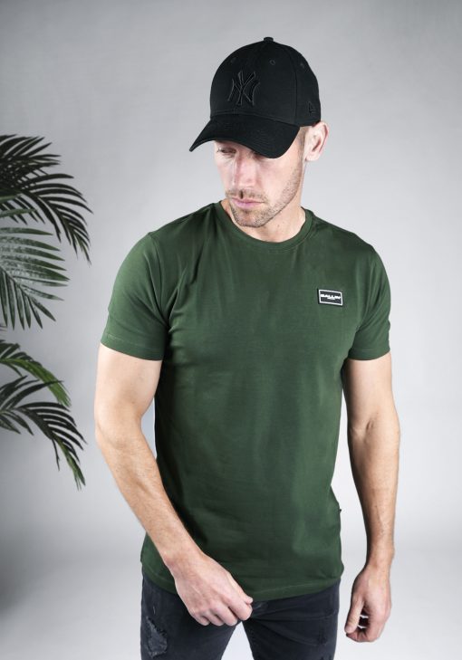 Vooraanzicht van model gekleed in donkergroen t-shirt met een kleine zwarte badge op de linkerborst met het witte Ballin logo.
